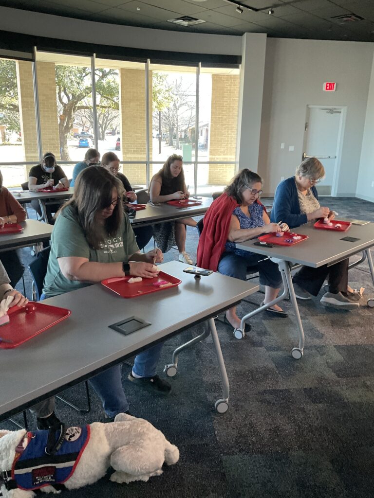 A group of people working on needle felting projects at the library