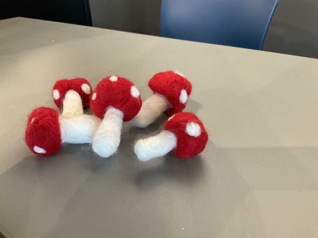 A pile of red and white felted mushrooms